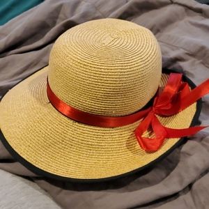 Straw hat, black rim and band. Added red ribbon.
